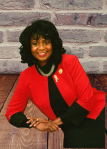 Woman wearing red jacket sitting welcoming visitors to her website