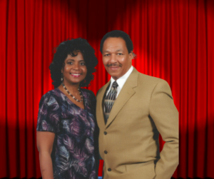woman wearing black dress, man wearing gold suit jacket talking on stage about marriage relationships, red background